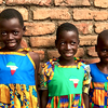 girls wearing dresses made by volunteers all over the world—courtesy the “Little Dresses for Africa” program.