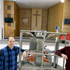 Pictured are senior pastor Rev. Eric Schwirian and pastoral assistant Allen Westby, right, with the mechanical lift to paint the upper reaches of Trinity’s high-ceiling worship area. 